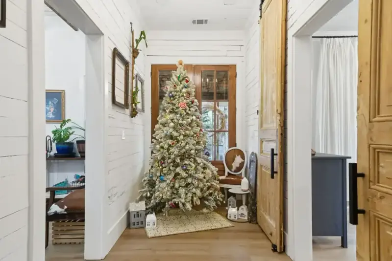 Hallway at 356 Hyde Road with a decorated tree, wood doors, and white paneled walls