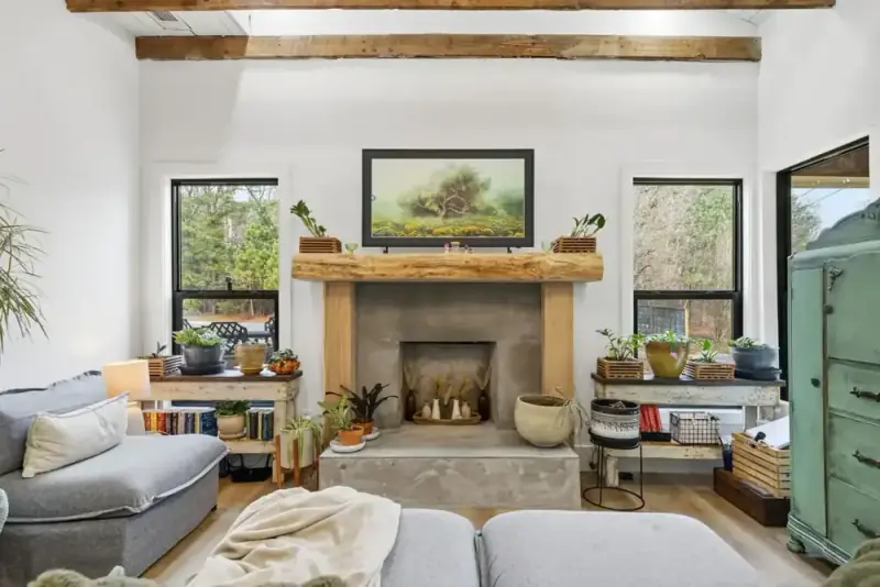 Bright living room at 356 Hyde Road with a stone fireplace, exposed ceiling beams, and large windows