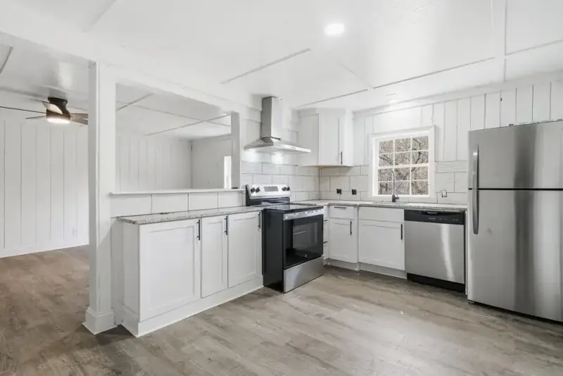 Renovated kitchen with white cabinets and granite counters at 6757 Henderson Mtn